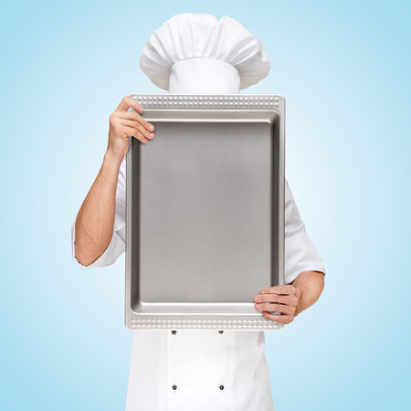 Restaurant chef hiding behind a baking pan for a business lunch menu with prices の写真素材