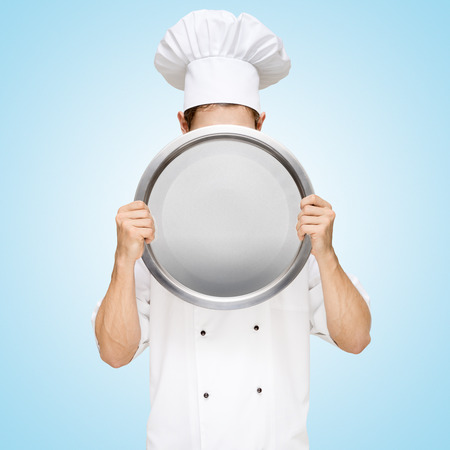 Restaurant chef hiding behind an empty dish for a business lunch menu with prices の写真素材
