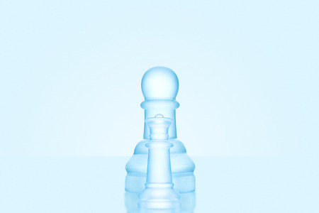 Chess game concept of a single icy frosted pawn standing alone on glacial chessboard.の写真素材
