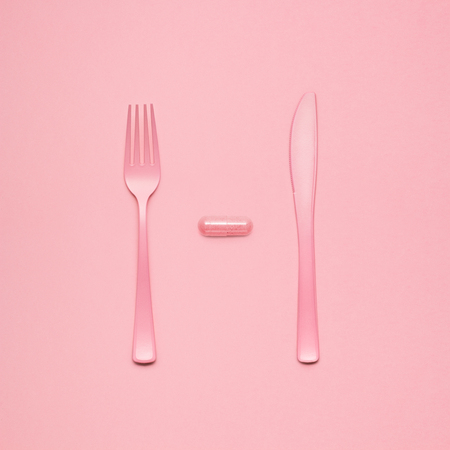 Still life of fork and knife at a lunchtime with a pill served.の写真素材