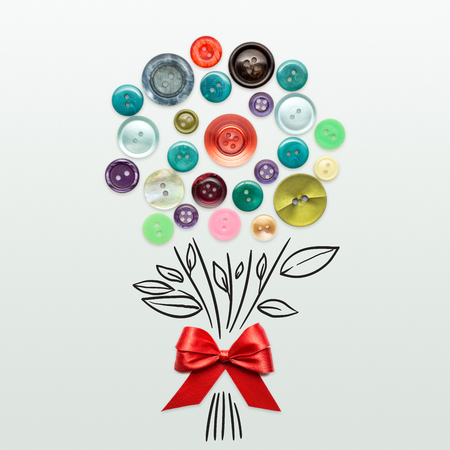 Creative valentines concept photo of a bouquet mad of buttons with a bow on grey background.の写真素材