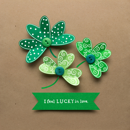 Creative St. Patricks Day concept photo of shamrocks made of paper on brown background.の写真素材