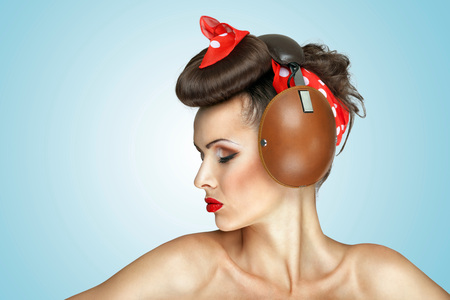 The retro photo of cute girl in vintage headphones listening to the music.の写真素材