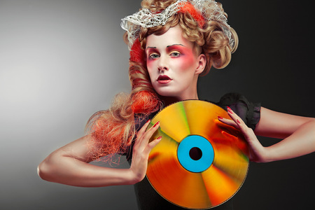 A glamorous vintage woman holding a retro laser disc.の写真素材