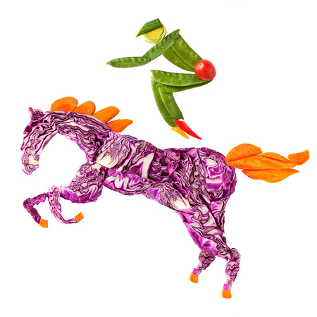 A food concept of a horse rider made of fruits and vegs isolated on white.の写真素材