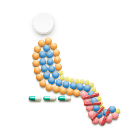 Creative medicine and healthcare concept made of drugs and pills, person with broken leg sitting and waiting in hospital isolated on white.の写真素材