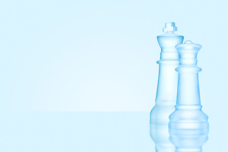 Chess game concept of icy frosted king and queen, the most powerful figures standing together on glacial chessboard.の写真素材