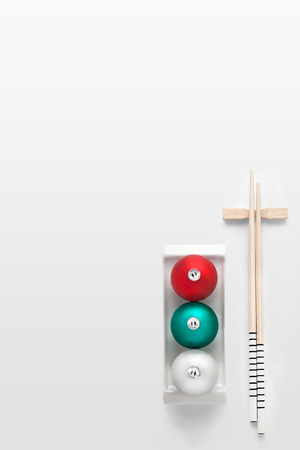A creative japanese sushi plate decorated with traffic lights Christmas balls and chopsticks.の写真素材