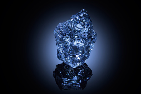 A professionally formed piece of ice on reflecting surface.の写真素材