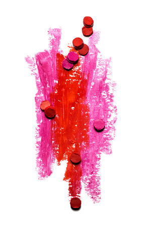 Creative photo of an abstract red and pink strokes with slices of lipstick isolated on white.の写真素材