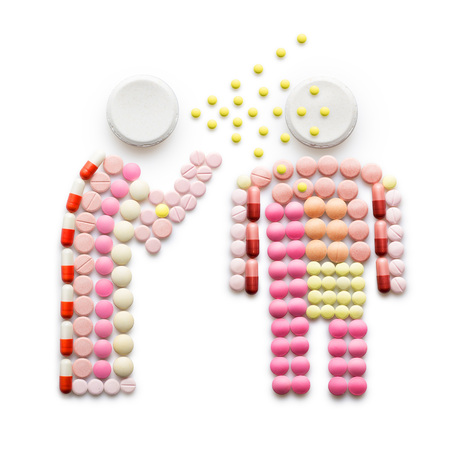 Creative health concept made of drugs and pills, isolated on white. A person that caught a cold, sneezing and spreading disease while standing near another person.の写真素材