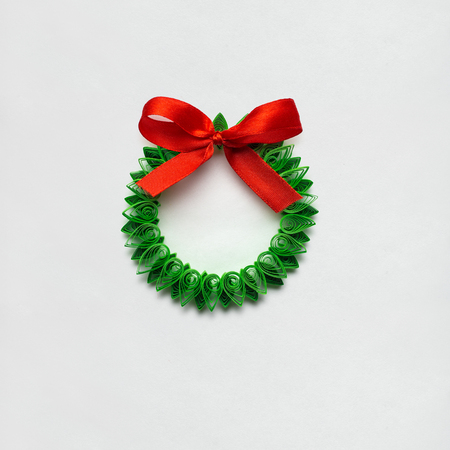 Creative concept photo of christmas wreath made of quilling paper on white background.の写真素材