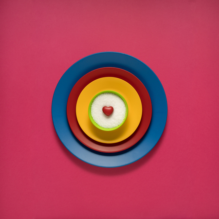 Creative concept photo of painted plates on pink background.の写真素材