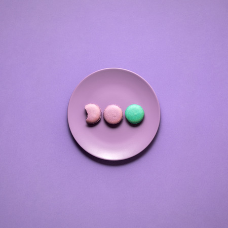 Creative concept photo of a painted plate on purple background.の写真素材