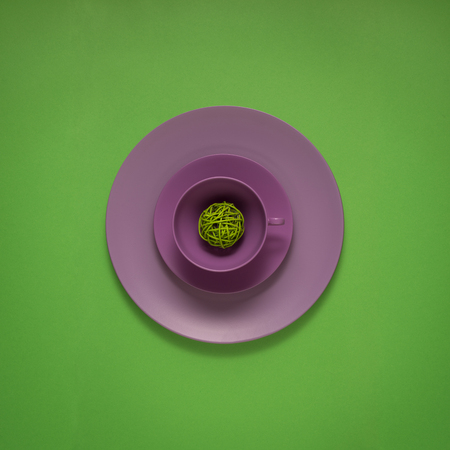 Creative concept photo of painted plates on green background.の写真素材