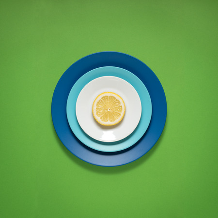 Creative concept photo of kitchenware, painted plate with food on it on green background.の写真素材