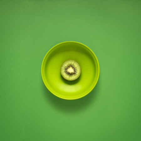 Creative concept photo of kitchenware, painted plate with food on it on green background.の写真素材