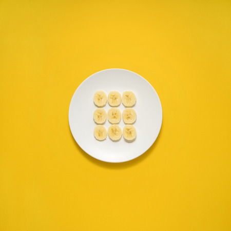 Creative concept photo of painted plates on yellow background.の写真素材