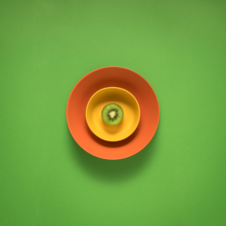 Creative concept photo of kitchenware, painted plate with food on it on green background.の写真素材