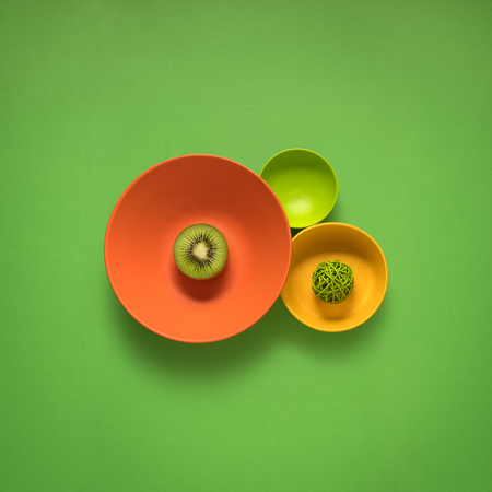 Creative concept photo of kitchenware, painted plate with food on it on green background.の写真素材