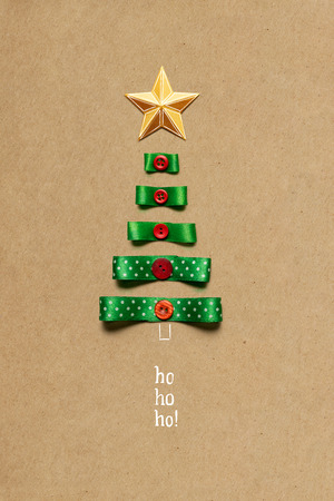Creative concept photo of christmas tree made of ribbon on brown background.の写真素材