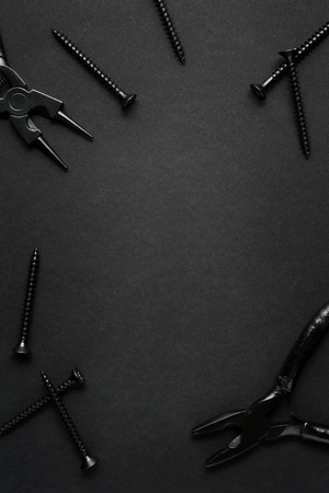 Creative concept photo of painted tools and nails on black background.の写真素材