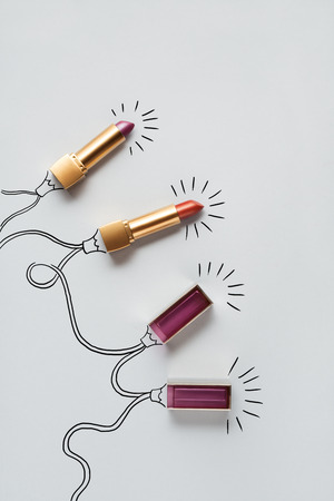 Creative concept photo of lipstick as christmas lights on grey background.の写真素材