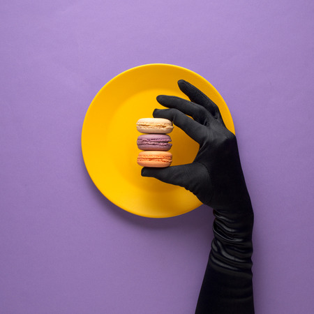Creative concept photo of kitchenware with hand, painted plate with food on it on purple background.の写真素材