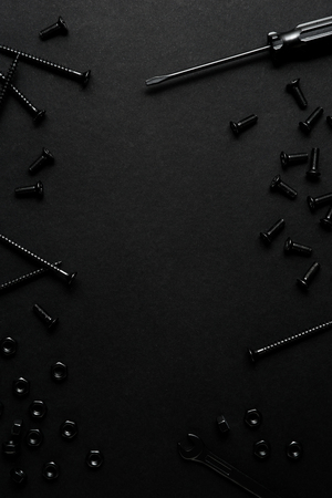 Creative concept photo of painted tools and nails on black background.の写真素材