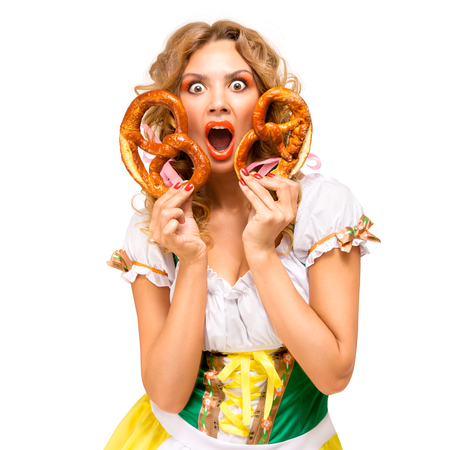 Creative concept photo of Oktoberfest waitress wearing a traditional Bavarian costume with pretzels isolated on white background.の写真素材