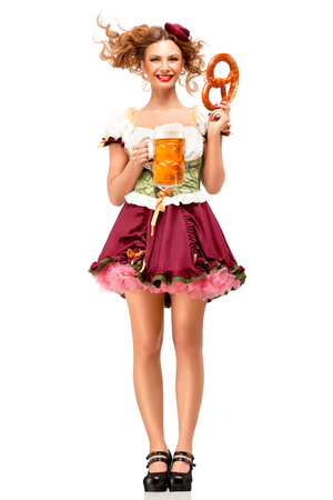 Creative concept photo of Oktoberfest waitress wearing a traditional Bavarian costume with beer and pretzel isolated on white background.の写真素材