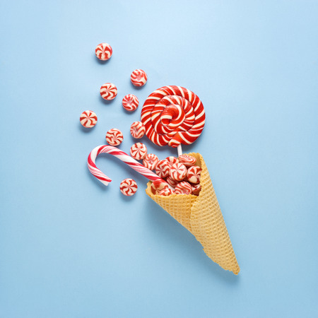 Creative concept photo of candies in waffle cone on blue background.の写真素材