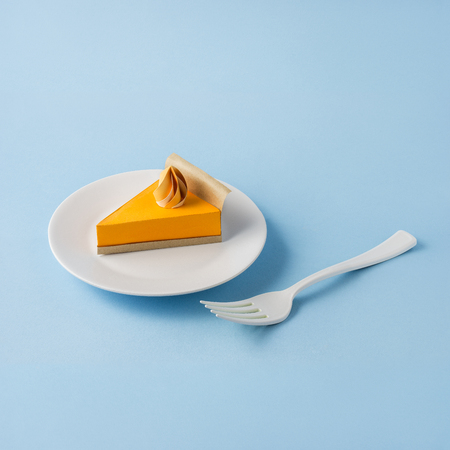 Creative thanksgiving day concept photo of a pumpkin pie made of paper on blue background.の写真素材