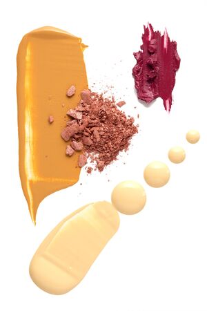 Creative concept photo of cosmetics swatches beauty products foundation cream with lipstick and eyeshadow on white background.の写真素材
