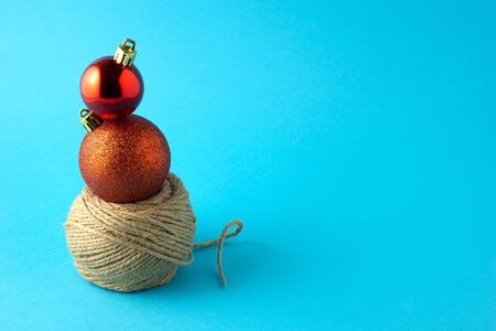 Creative concept still life holiday photo of Christmas toys balls decorations and decorative rope on blue background.の写真素材