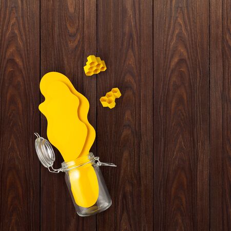 Creative concept still life food health photo of bottle jar of honey made of paper on wooden background.の写真素材