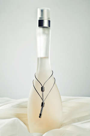 Perfume bottle on grey background and silk sheetsの写真素材