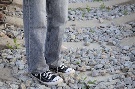 a man walking on rails, a view of feet walking on railroad tracks. High quality photo