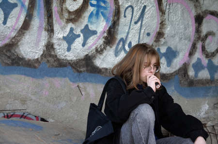 teenage girl sitting in an abandoned building smoking. High quality photo