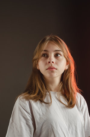portrait of a girl in a white T-shirt on a dark background. High quality photo