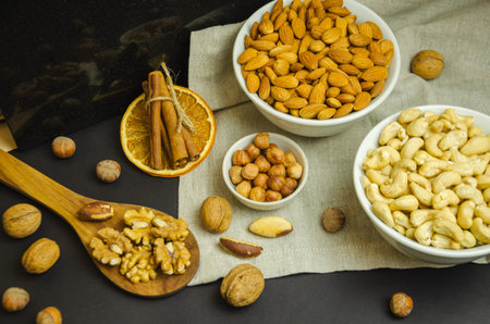 nuts in different plates and on a wooden spoon, nutty still life. High quality photo