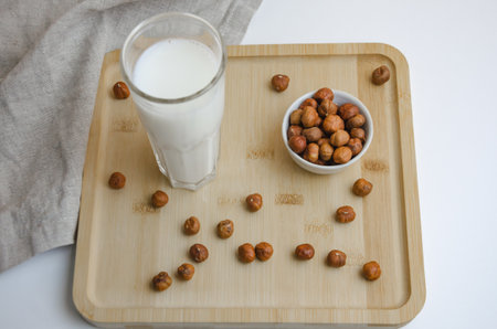 on a wooden board hazelnut nuts and a glass of milk, the concept of milk from nuts. High quality photoの写真素材