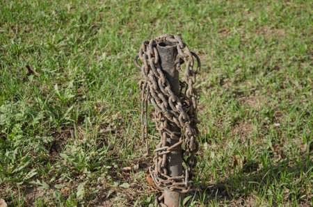 The rusty chain is wound on an iron pole. High quality photo