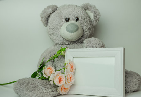 Gray bear toy with bouquet of roses. High quality photo