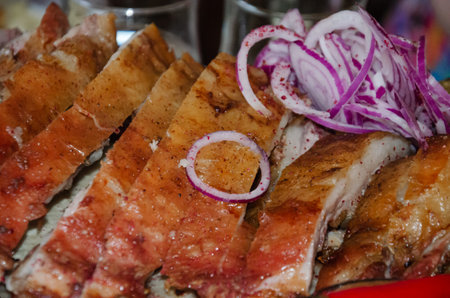 Roast pork in the oven cut into chunks and sprinkled with fresh onions. High quality photoの写真素材