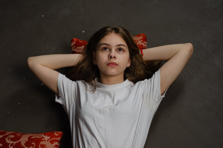Portrait of a girl lying on the floor, dark background. High quality photo