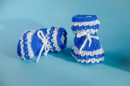 blue knitted boots on a blue background. High quality photo