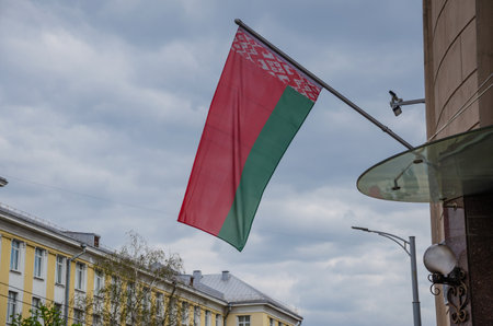 red-green Belarusian flag on the wall of a house against the blue sky, Republic of Belarus. High quality photoの写真素材