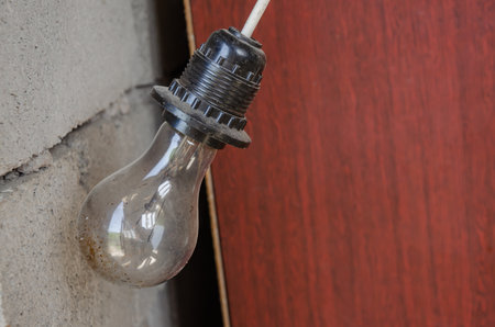 electric lamp in an old socket on the wall of a house during renovation. High quality photoの写真素材