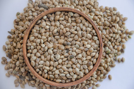 Hemp seeds in wooden plate on white background. High quality photoの写真素材